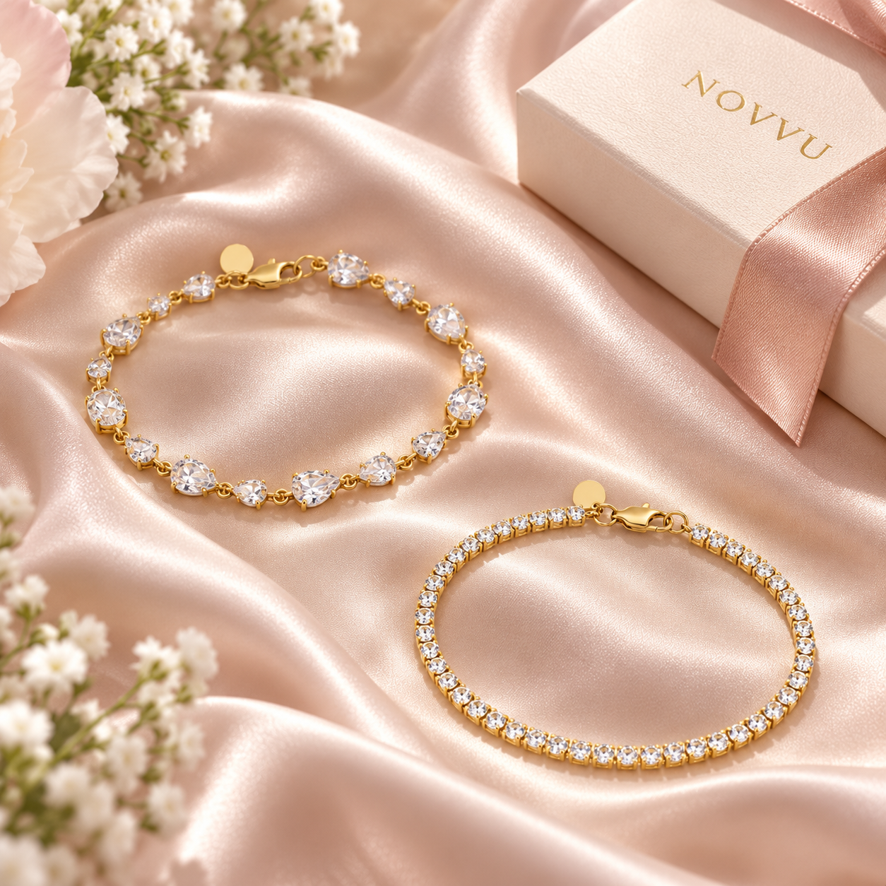 Cele două brățări Love & Tennis Gold, pe satin, alături de cutia NOVVU