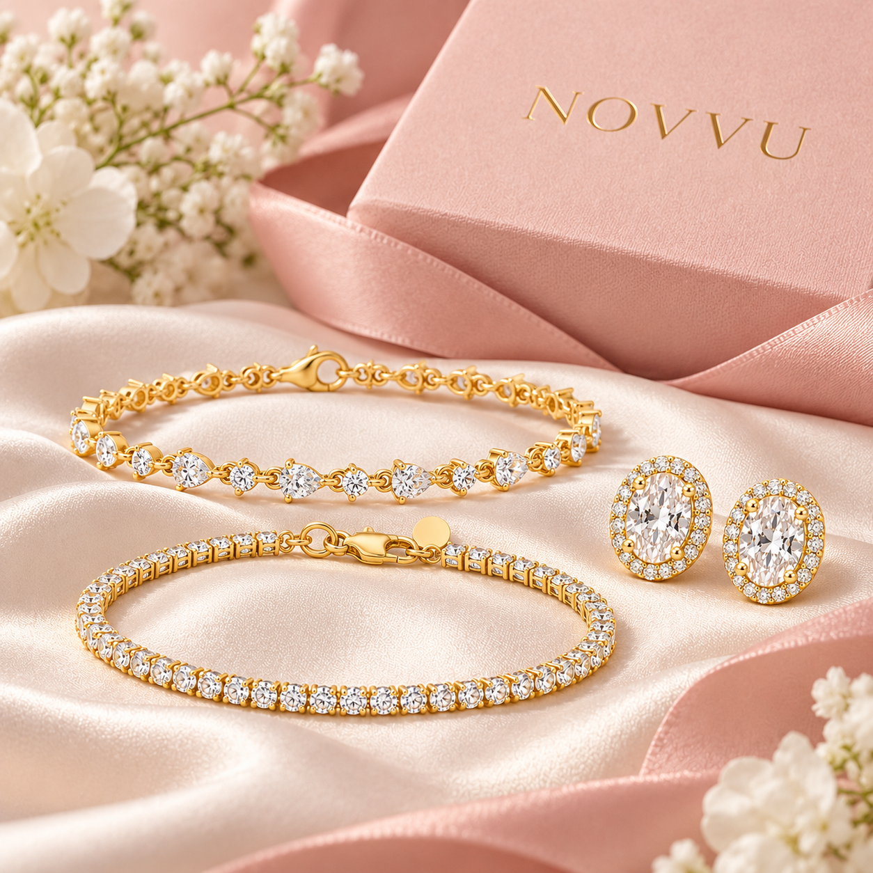 Cele trei bijuterii Love & Tennis Gold Trio, pe satin, alături de cutia NOVVU